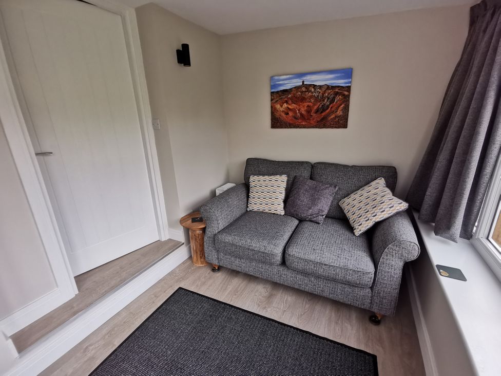 A living room with a sofa and cushions at Caledfryn in Benllech