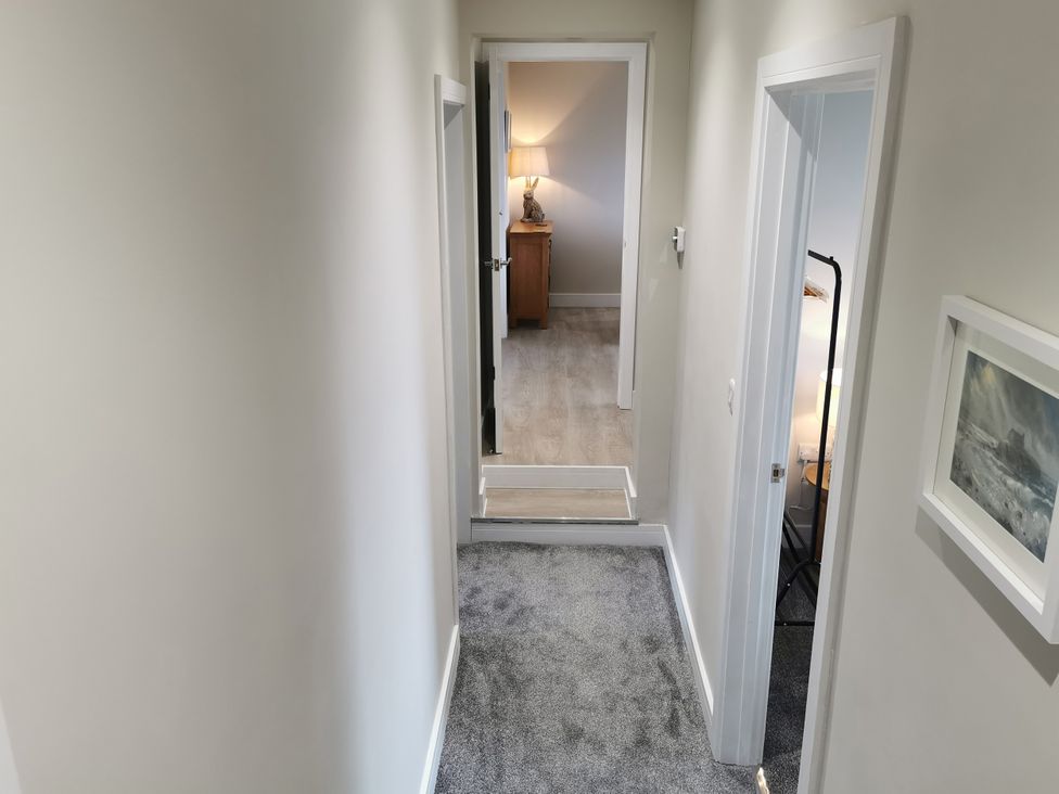 A hallway with carpet and a lamp at Caledfryn in Benllech