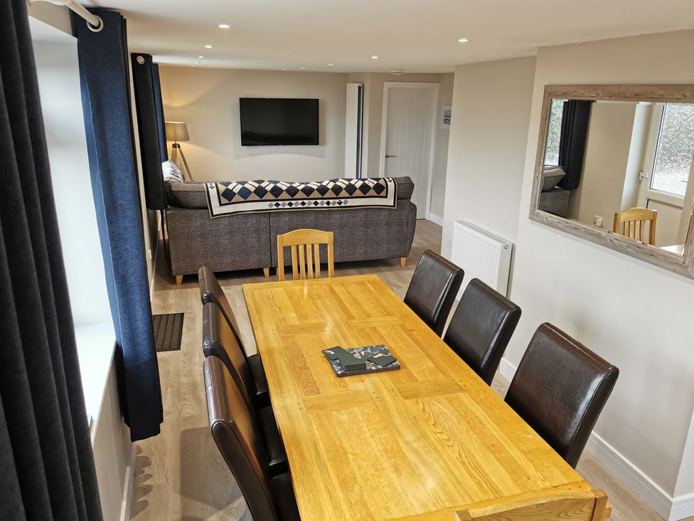A dining room with a table and chairs at Caledfryn in Benllech