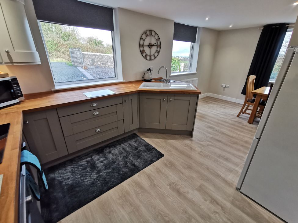 A kitchen with a sink and table at Caledfryn in Benllech