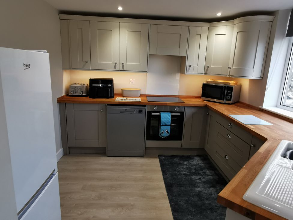 A kitchen with appliances and storage at Caledfryn in Benllech