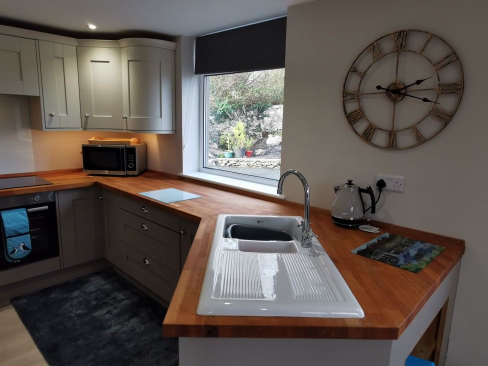 A kitchen with a sink and microwave at Caledfryn in Benllech