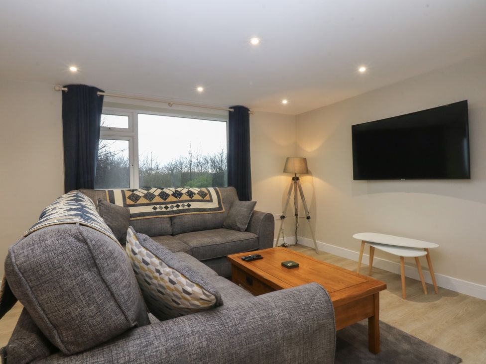 A living room with a sofa and coffee table at Caledfryn in Benllech