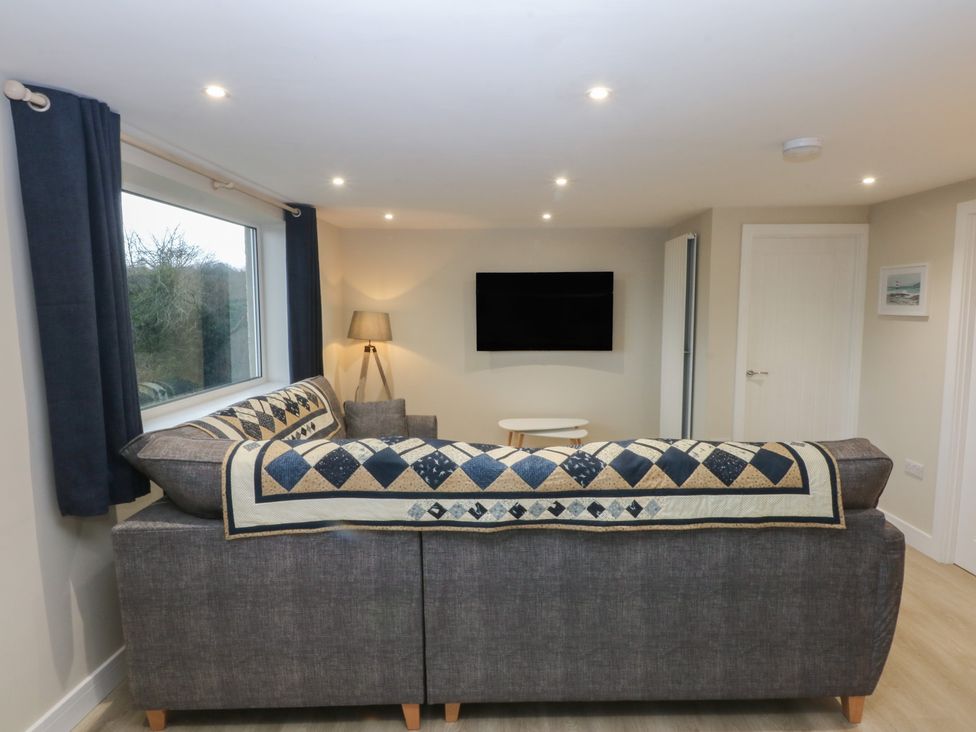 A living room with a sofa and television at Caledfryn in Benllech