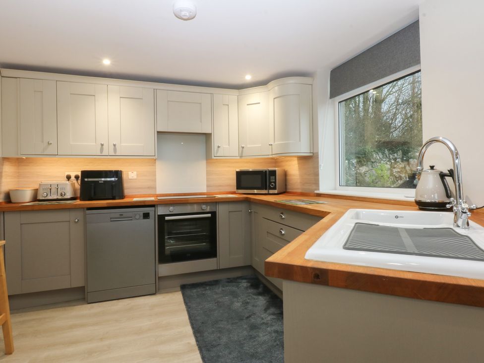 A kitchen with appliances and cabinets at Caledfryn in Benllech