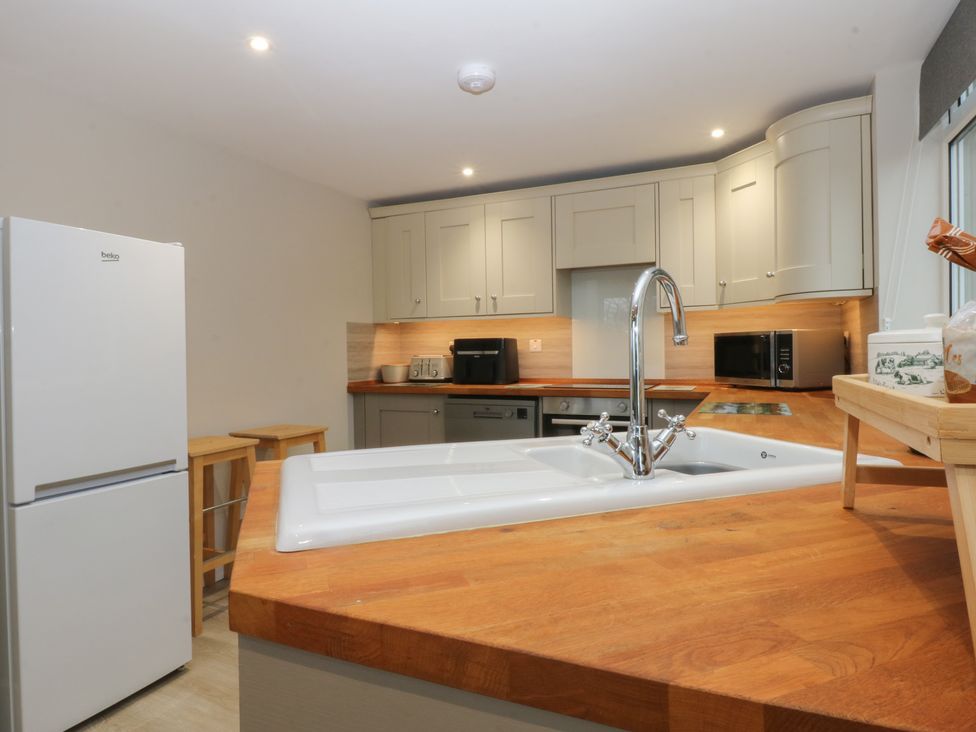 A kitchen with a refrigerator and sink at Caledfryn Benllech
