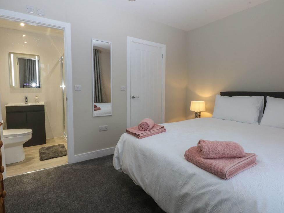 A bedroom with a bed and towels at Caledfryn in Benllech