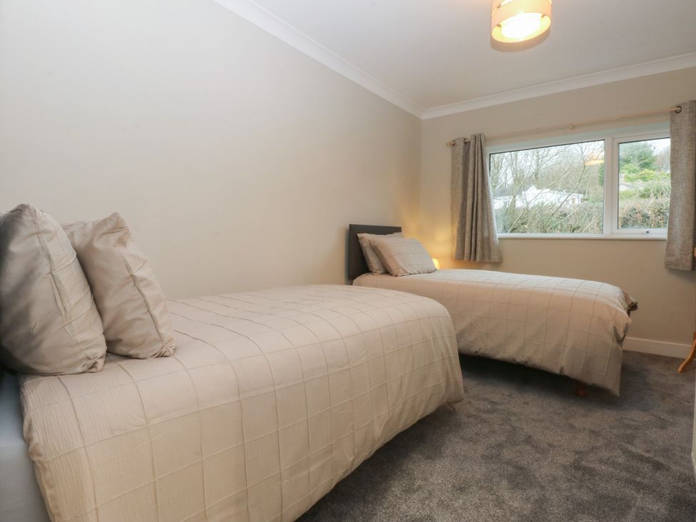 A bedroom with two beds and a window at Caledfryn in Benllech