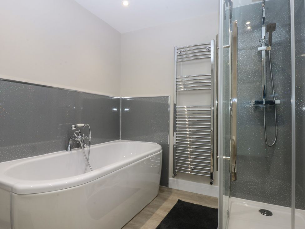 A bathroom featuring a bathtub and shower at Caledfryn in Benllech