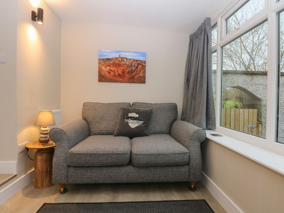 A living room with a sofa and lamp at Caledfryn in Benllech