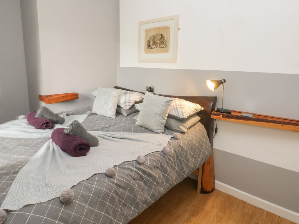 A bedroom with a bed and bedside shelf at Llys-Yr-Onnen in Carmarthen