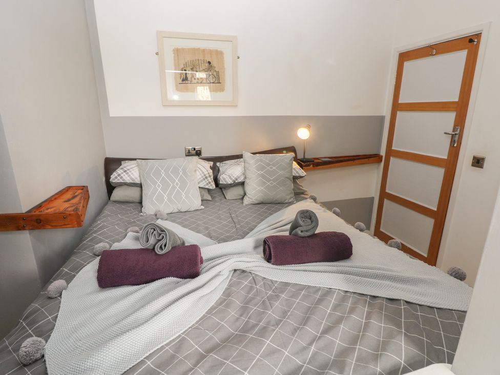 A bedroom with a bed and towels at Llys-Yr-Onnen in Carmarthen