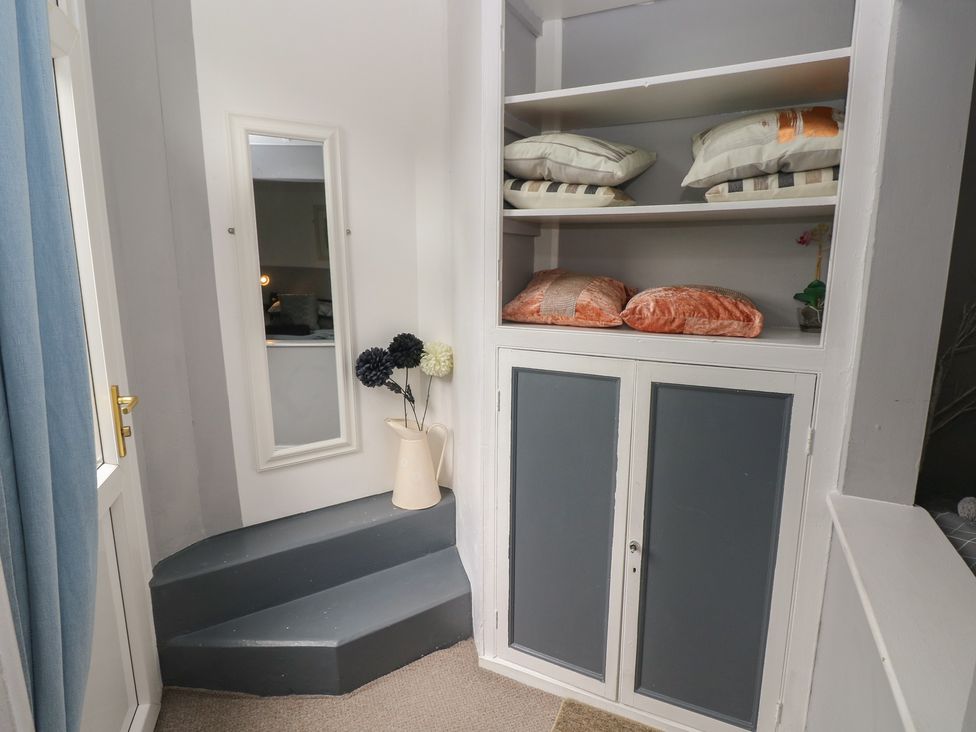 A hallway with a mirror and a shelf containing cushions at Llys-Yr-Onnen in Carmarthen