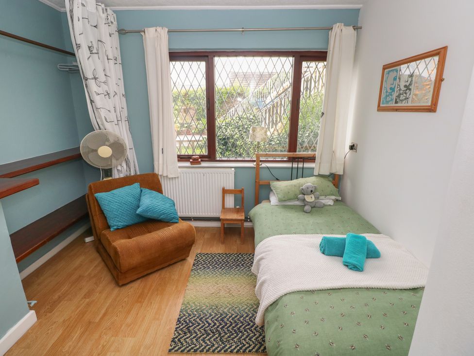 A bedroom with a bed and chair at Llys-Yr-Onnen in Carmarthen