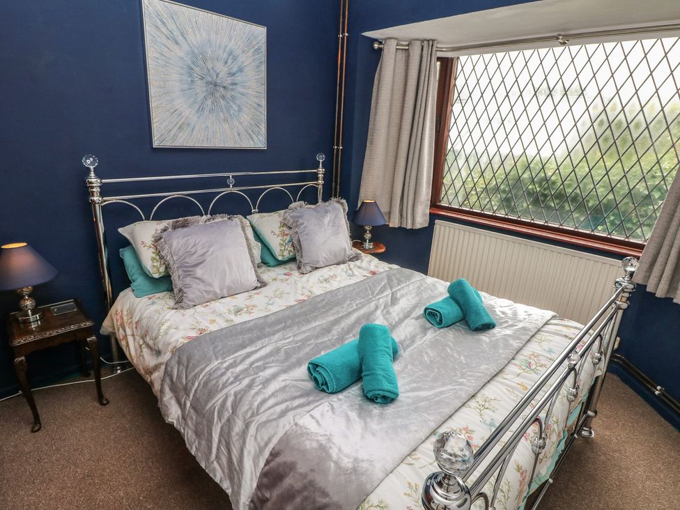 A bedroom with a bed and window at Llys-Yr-Onnen in Carmarthen