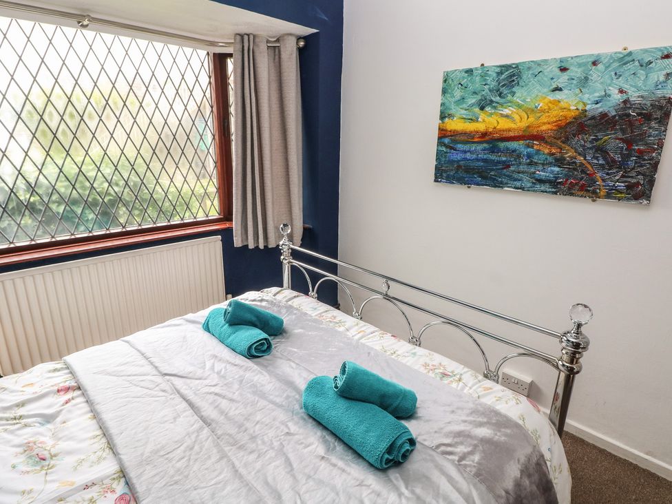 A bedroom with a bed and towels at Llys-Yr-Onnen in Carmarthen