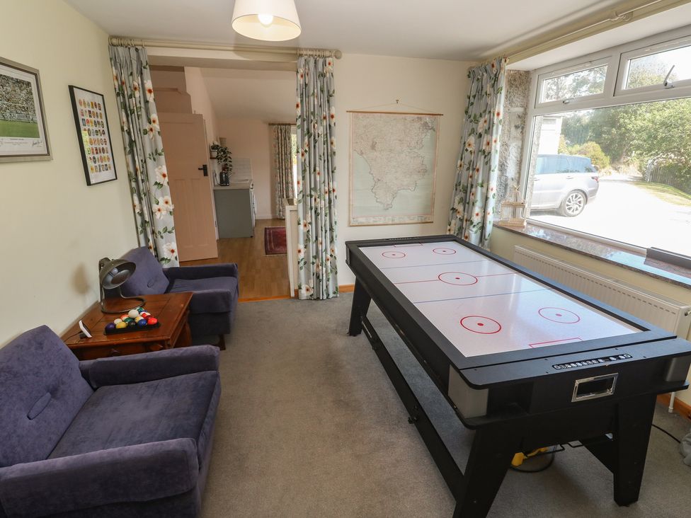A snug with an air hockey table and a sofa at Penmarth House in Coverack