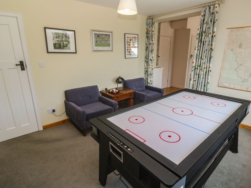 A game room with an air hockey table and seating at Penmarth House in Coverack
