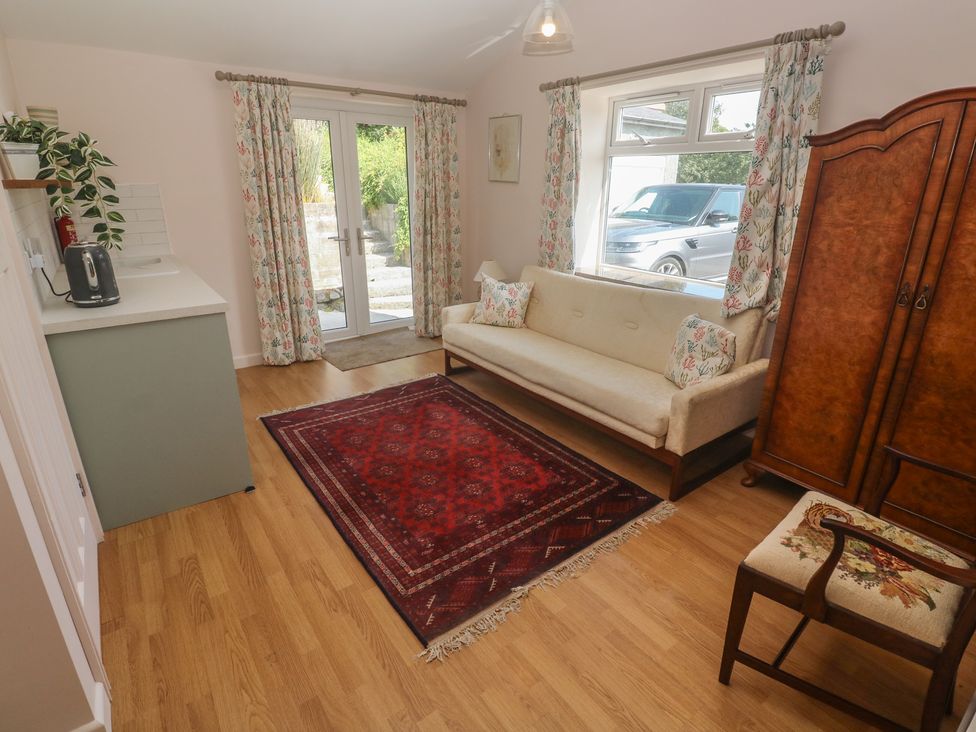 A living room with a sofa and cabinet at Penmarth House Coverack
