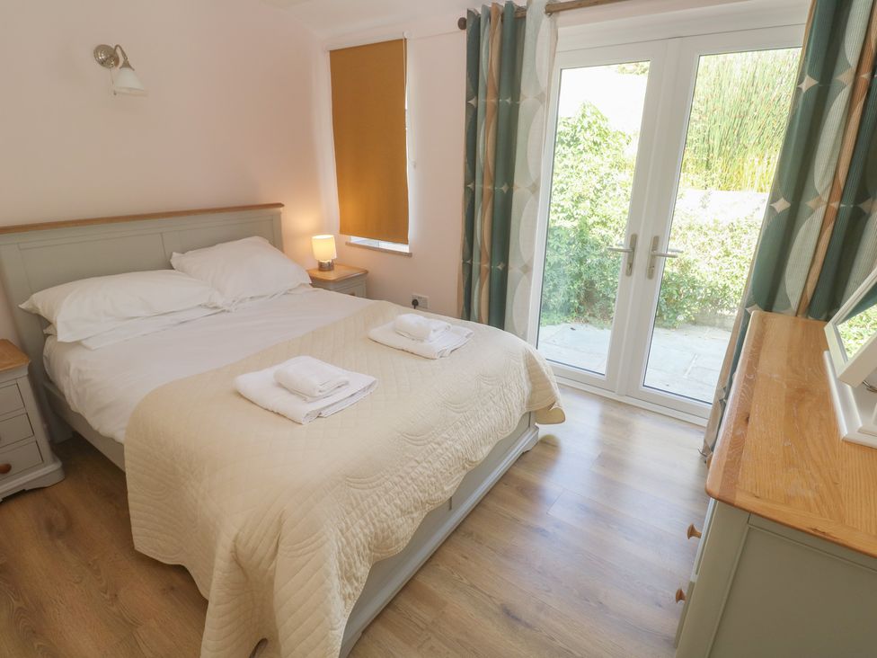 A bedroom with a bed and dresser at Penmarth House in Coverack
