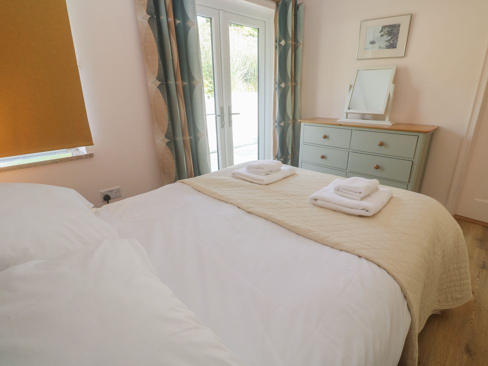 A bedroom with a bed and dresser at Penmarth House, Coverack