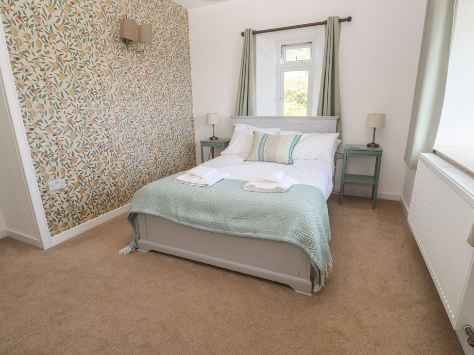 A bedroom with a bed and bedside tables at Penmarth House in Coverack