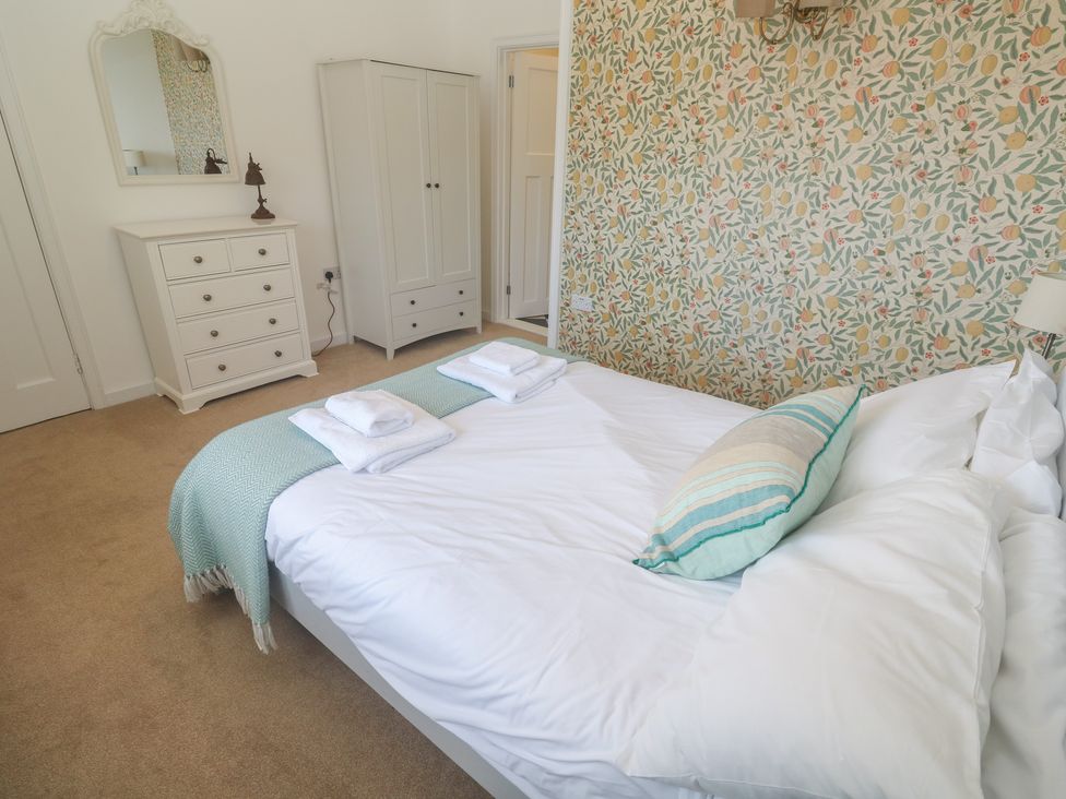 A bedroom with a bed and dresser at Penmarth House in Coverack