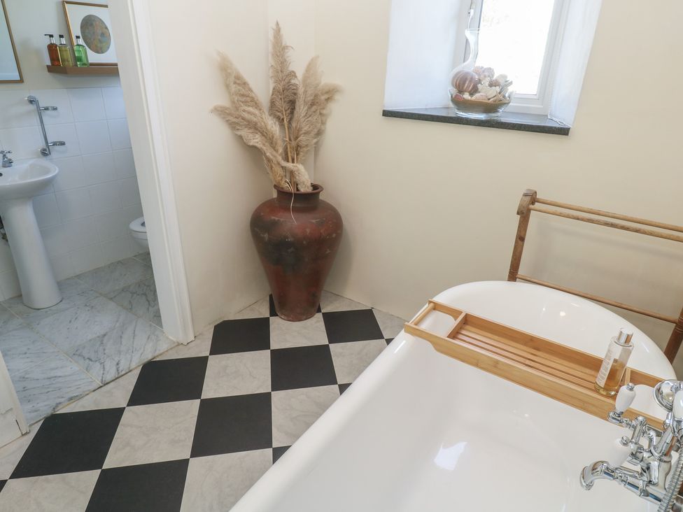A bathroom with a bathtub and sink at Penmarth House Coverack
