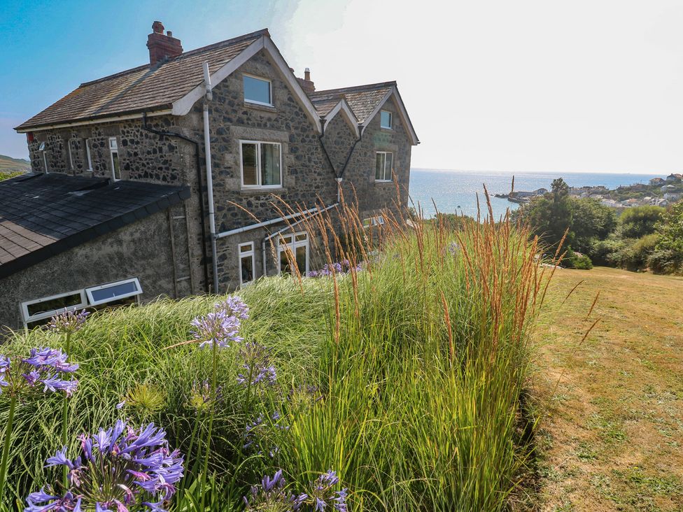 A house with flowers and grass overlooking the sea at Penmarth House Coverack