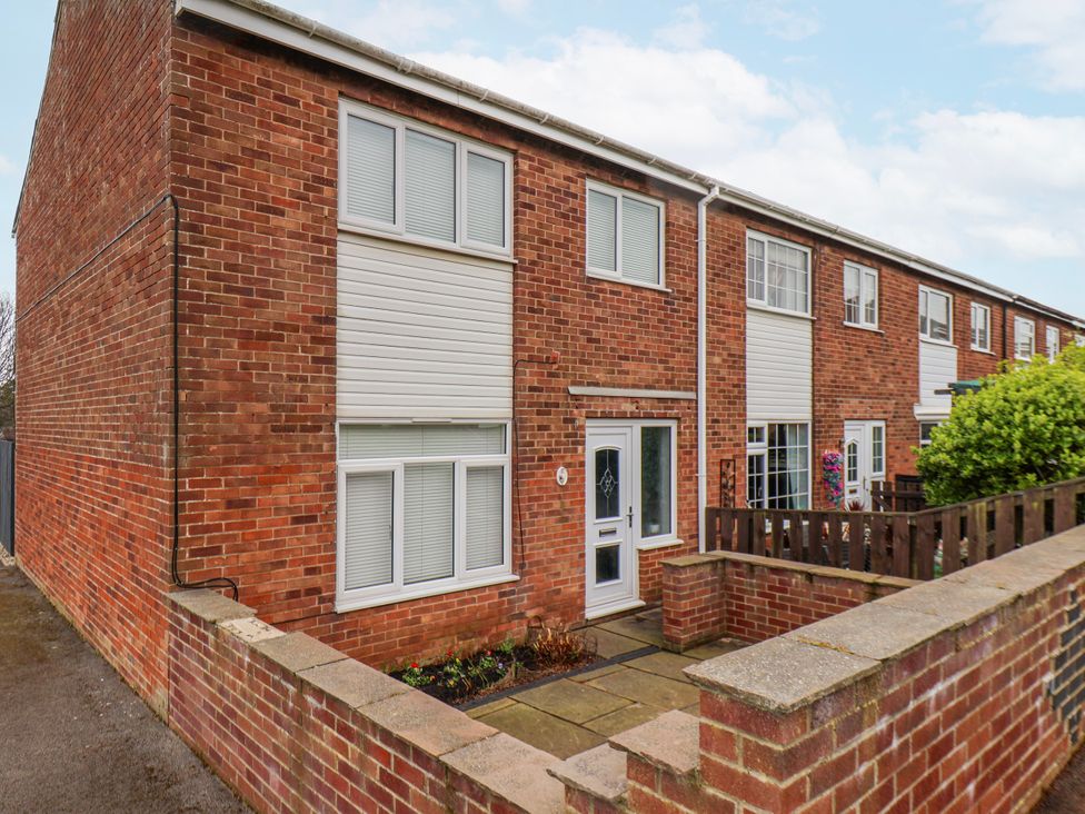An exterior view of a house with a brick wall and garden at 34 Fountain Close Whitby