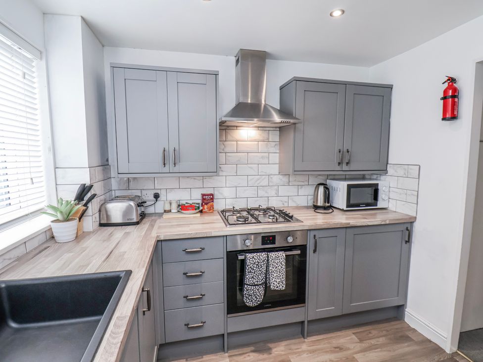 A kitchen with grey cabinets and appliances at 34 Fountain Close Whitby