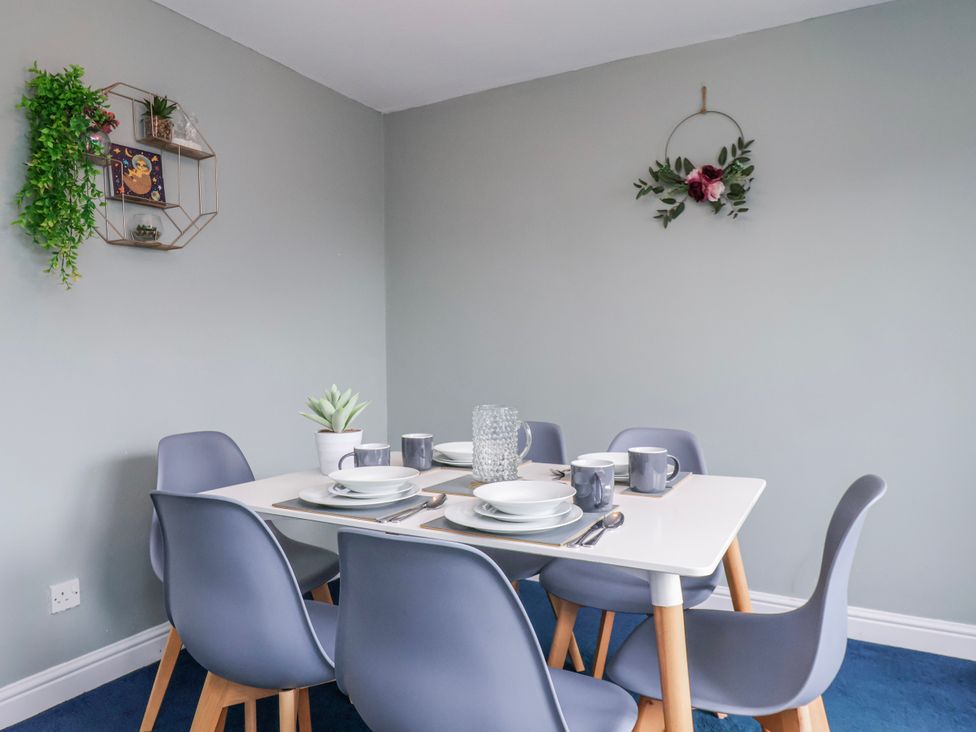 A dining room with a table set for meals at 34 Fountain Close in Whitby