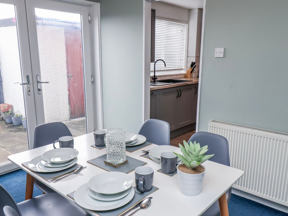 A dining room with a table set for meals at 34 Fountain Close in Whitby