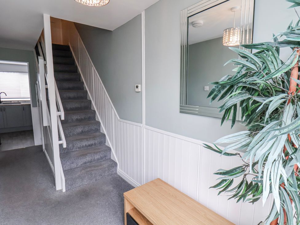 A hallway with stairs and a bench at 34 Fountain Close, Whitby