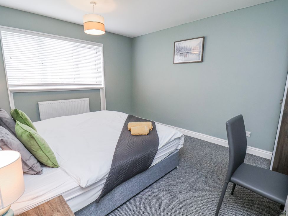 A bedroom with a bed and chair at 34 Fountain Close in Whitby