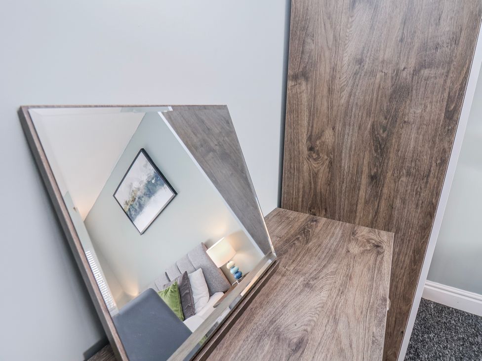A mirror and table in a living room at 34 Fountain Close Whitby