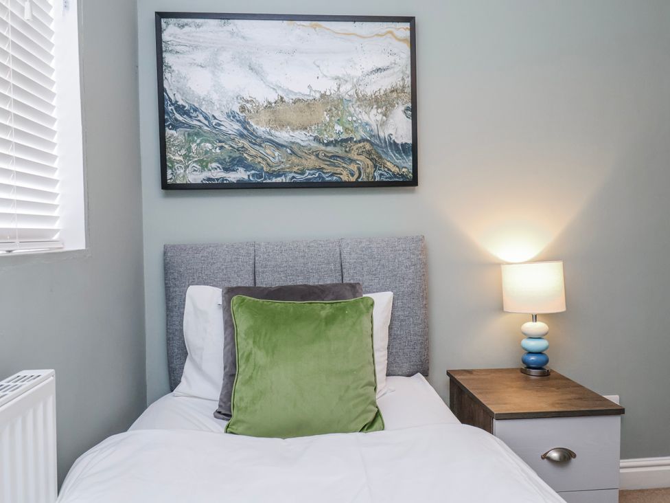 A bedroom with a bed and nightstand at 34 Fountain Close in Whitby