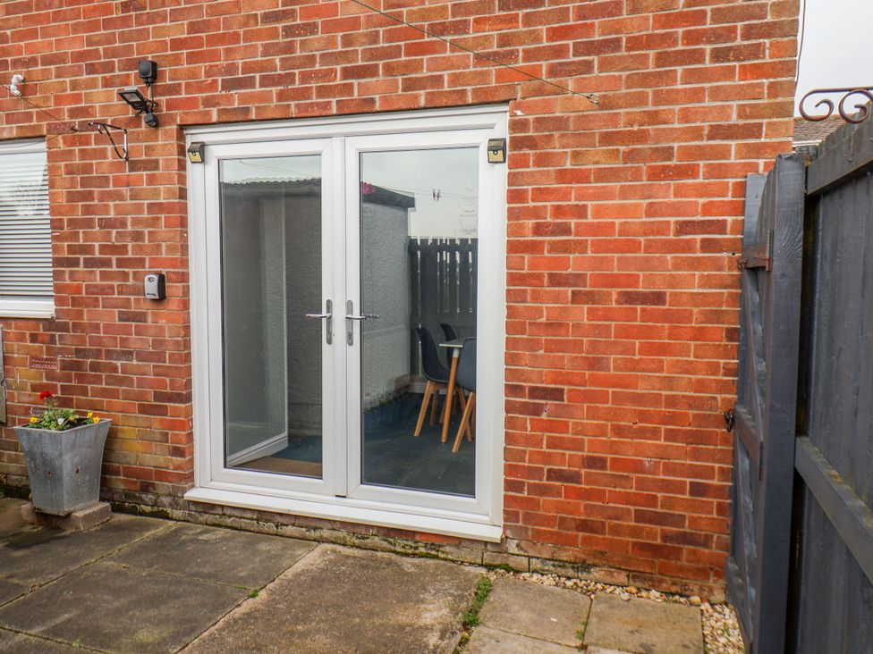 An outdoor area with a sliding door and a table and chair at 34 Fountain Close Whitby