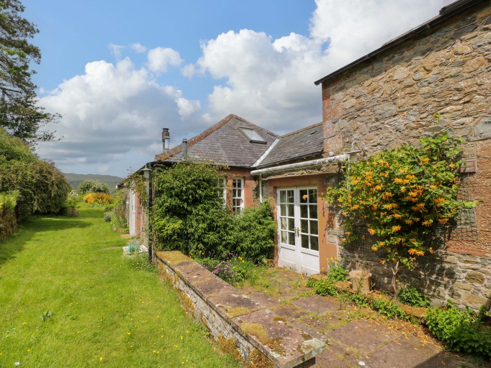 An outdoor area with a garden and stone wall at Townhead of Auchenbainzie near Thornhill