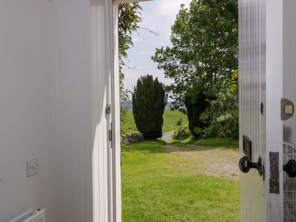 An open door leading to a grassy path and trees at Townhead of Auchenbainzie near Thornhill