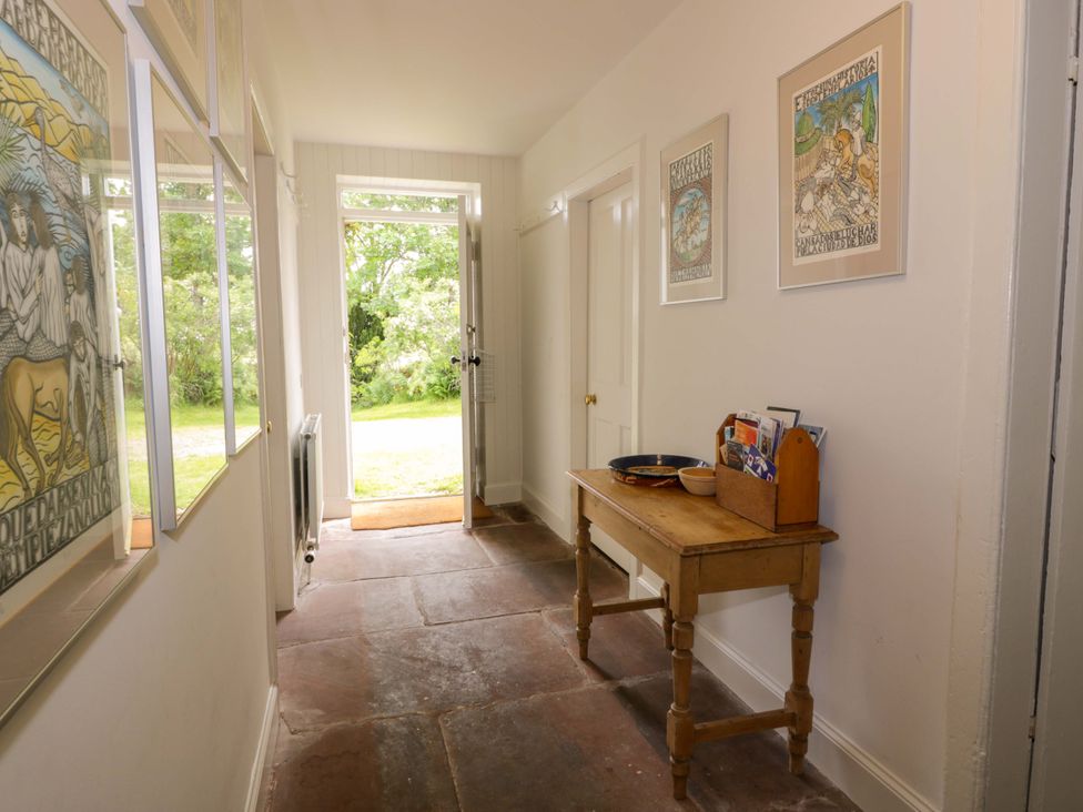 A hallway with a table and door to the outside at Townhead of Auchenbainzie near Thornhill