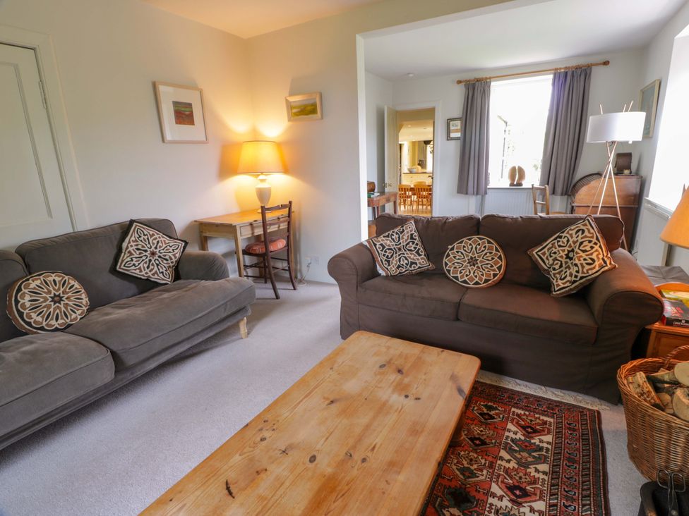 A living room with sofas and a wooden table at Townhead of Auchenbainzie near Thornhill