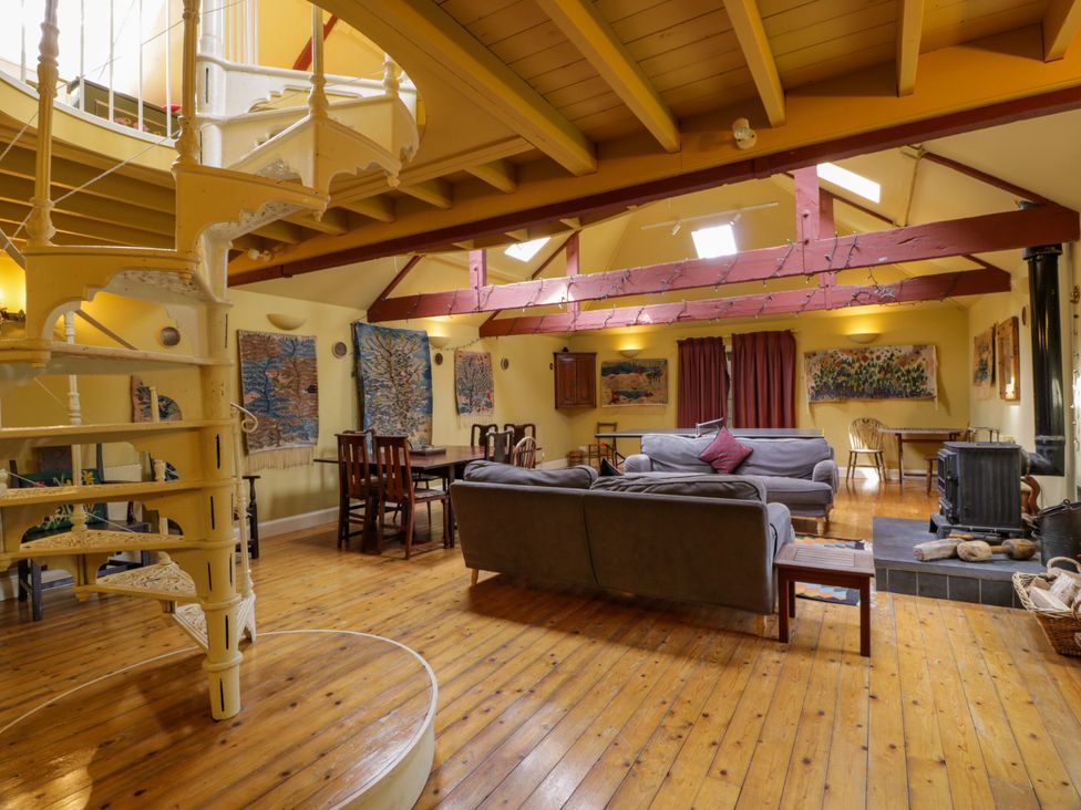 A living room with a spiral staircase and a sofa at Townhead of Auchenbainzie near Thornhill