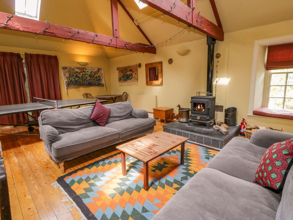 A living room with a fireplace and sofas at Townhead of Auchenbainzie near Thornhill