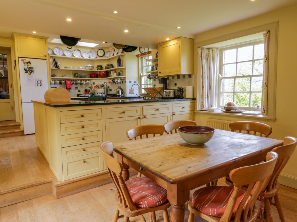 A kitchen with a table and chairs and shelves at Townhead of Auchenbainzie near Thornhill