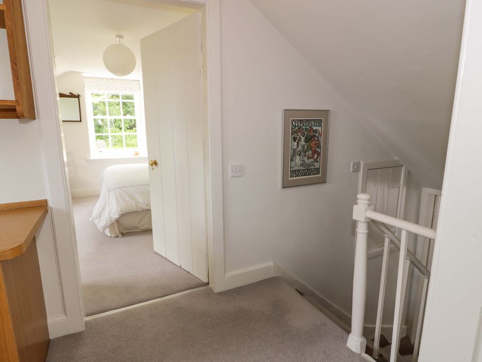 A hallway with a staircase and door leading to a bedroom at Townhead of Auchenbainzie near Thornhill