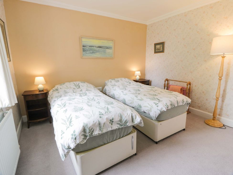 A bedroom with twin beds and a bedside table at Townhead of Auchenbainzie near Thornhill