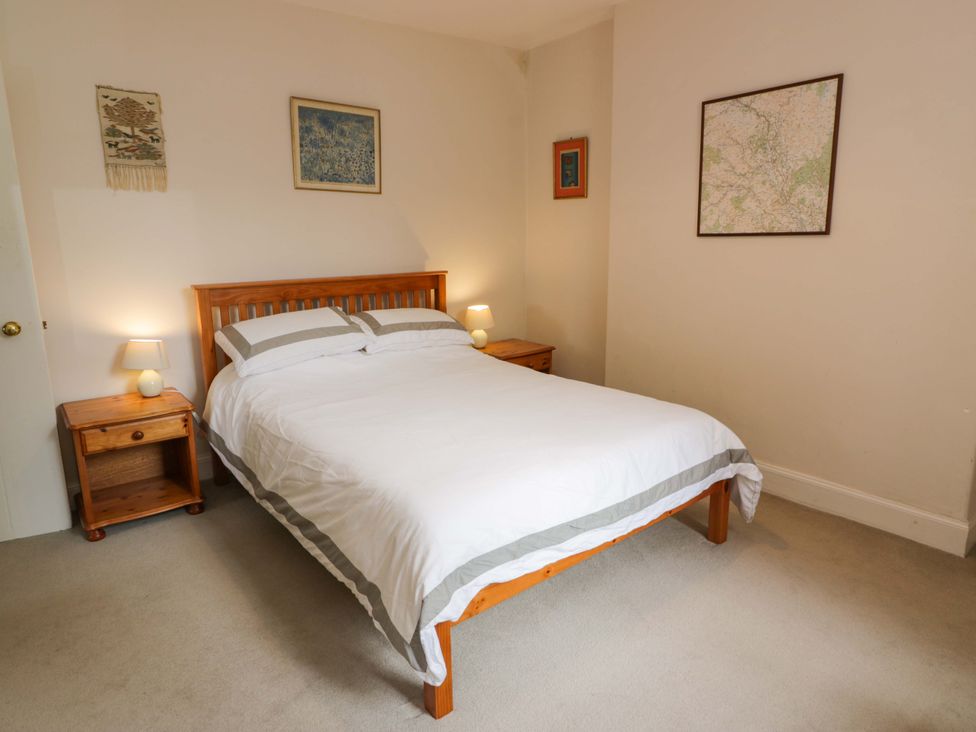 A bedroom with a bed and two bedside tables at Townhead of Auchenbainzie near Thornhill
