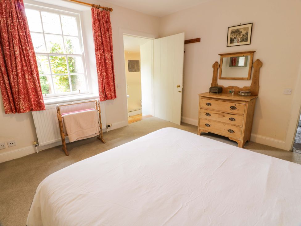 A bedroom featuring a bed, dresser, and window at Townhead of Auchenbainzie near Thornhill