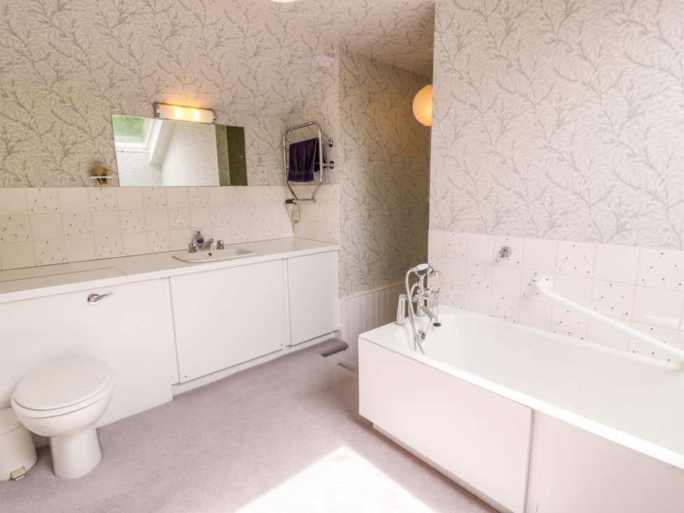 A bathroom with a bathtub, toilet, and sink at Townhead of Auchenbainzie near Thornhill